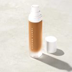 A sleek bottle of Pro Filt'r Soft Matte Longwear Foundation, featuring a luxurious frosted glass design with a minimalist pump dispenser. The rich, velvety formula is visible, promising a smooth, shine-free, long-lasting finish for all skin tones